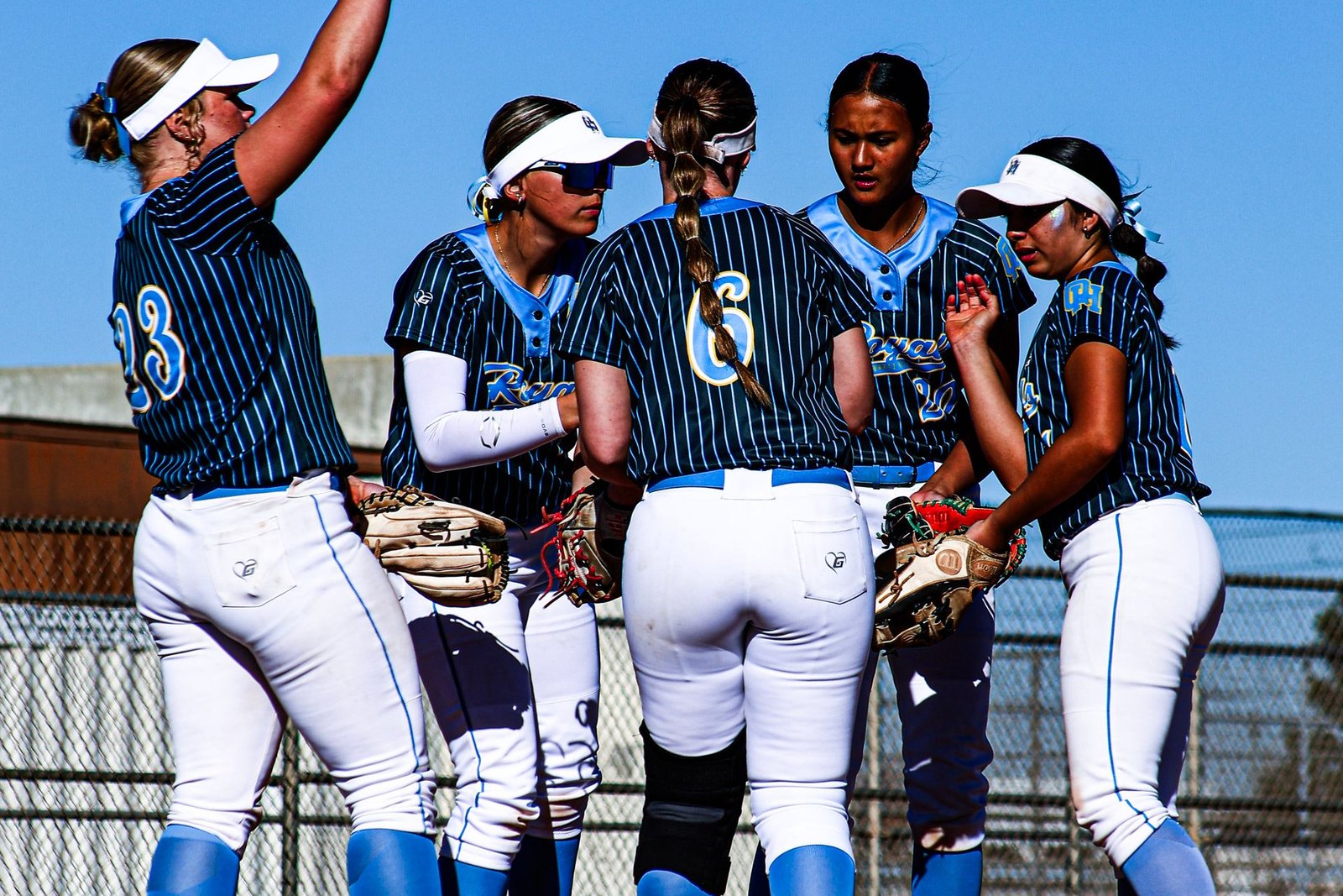 Youth softball players celebrating together on a community sports field